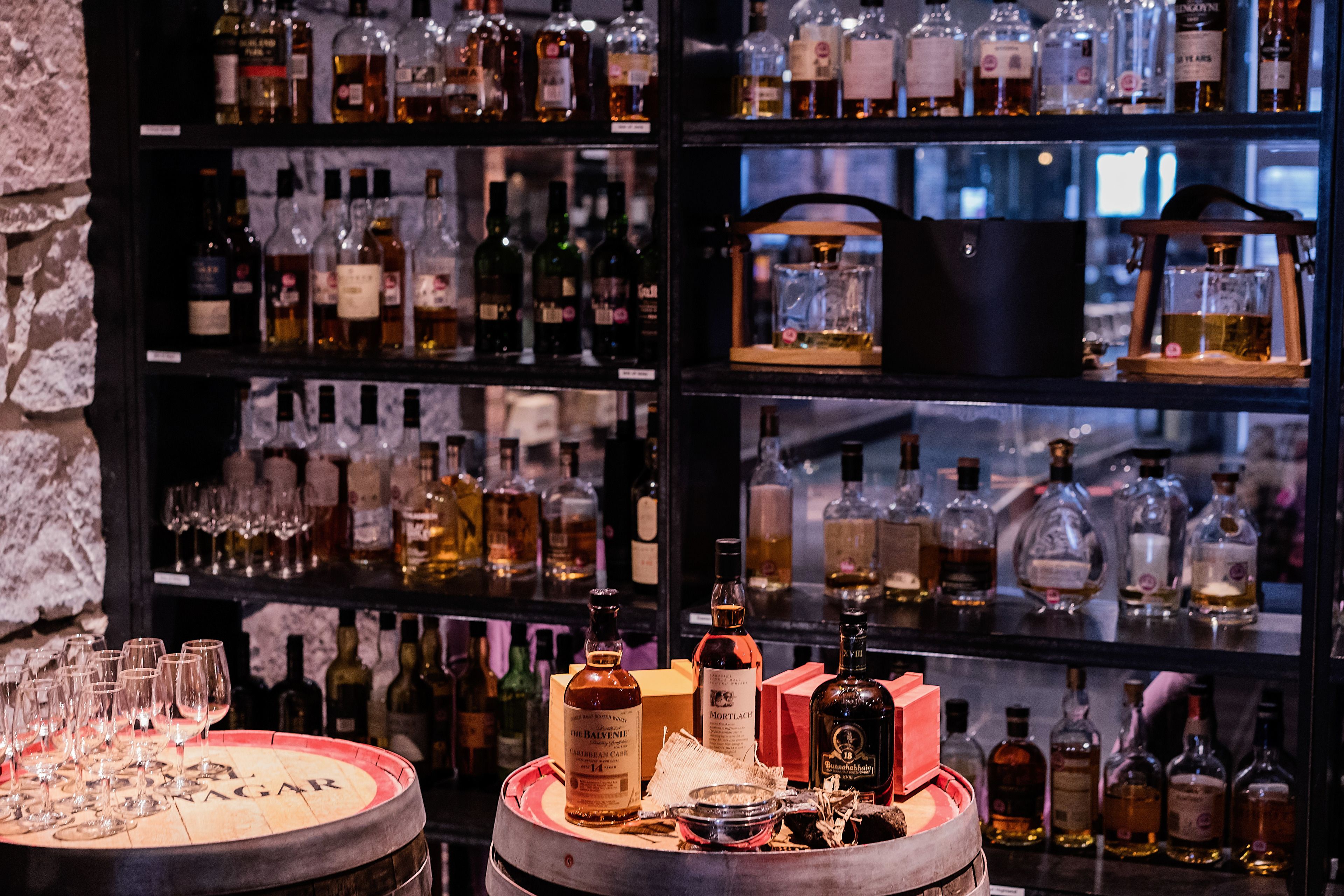 A bar area with shelves of liquor bottles and glasses.