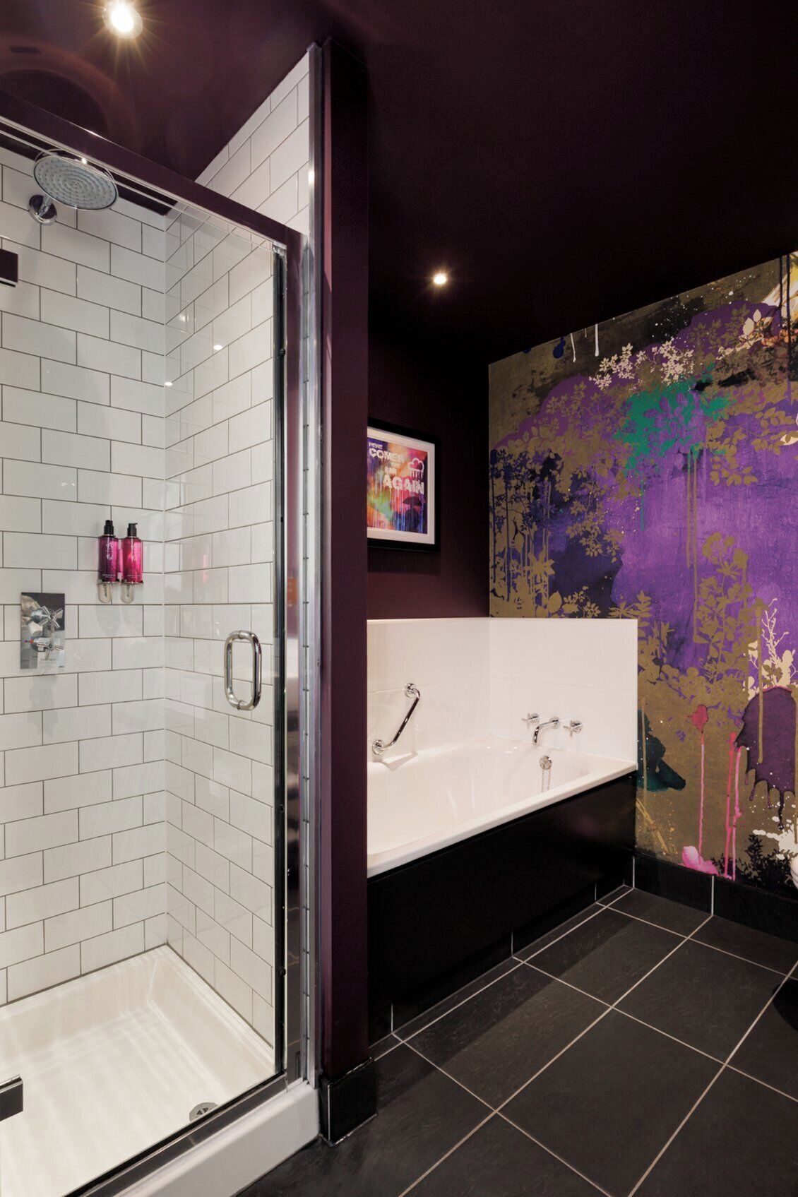 A modern bathroom with a glass shower enclosure, a white bathtub, and a large mirror.