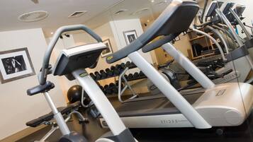 A gym with treadmills, dumbbells, and exercise equipment.