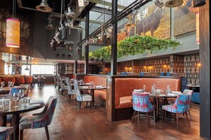 A restaurant with wooden flooring, booths, and tables with chairs. - Malmaison Aberdeen (Aberdeen)