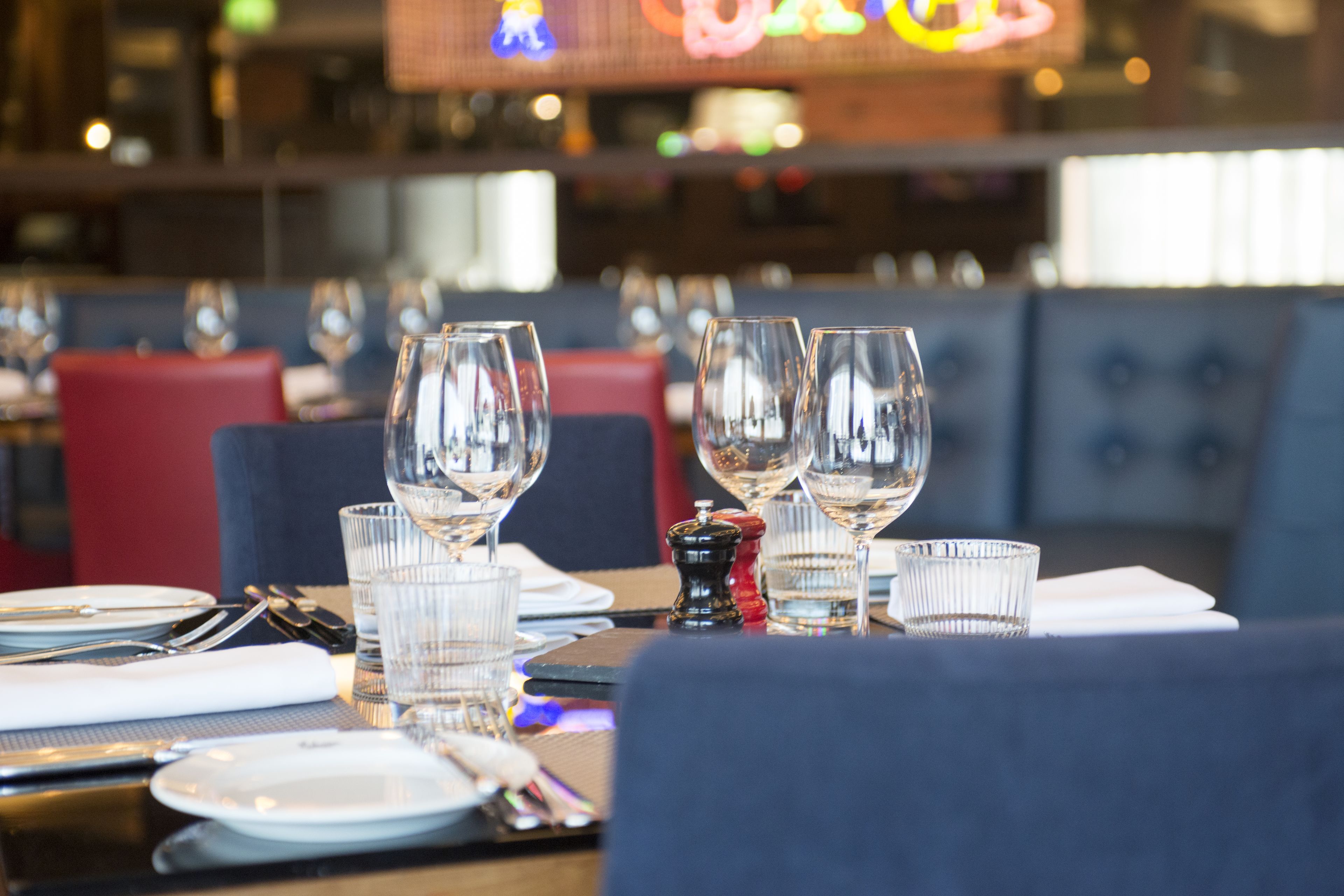 A restaurant setting with tables set for dining, including plates, glasses, and cutlery.