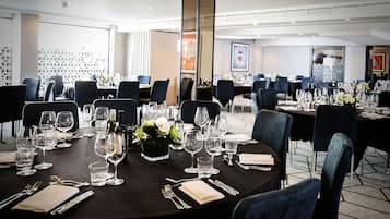 A restaurant with round tables set for dining, featuring clear glassware and napkins.