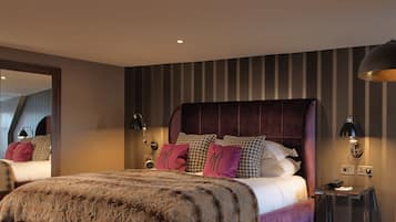 A modern bedroom with a large bed, striped wallpaper, and a mirror.