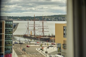 A large ship docked at a harbor with buildings in the foreground. - Malmaison Dundee (Dundee)