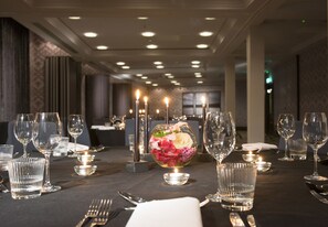 A dining table set with clear glassware, candles, and a floral centerpiece. - Malmaison Dundee (Dundee)