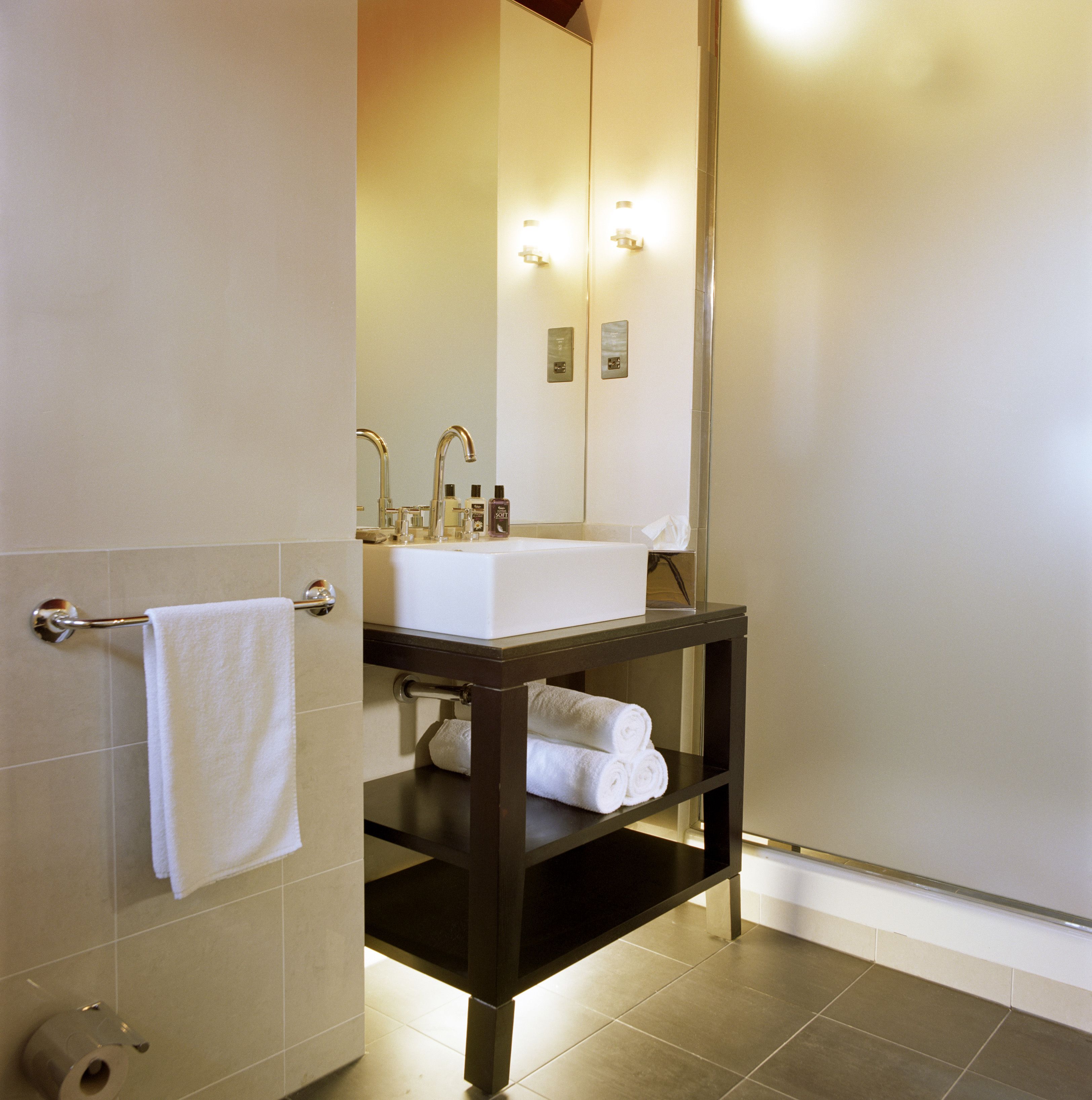 A bathroom with a white sink, a mirror, and a towel rack.