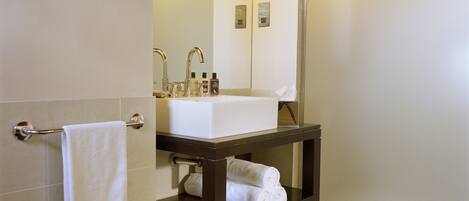 A bathroom with a white sink, a mirror, and a towel rack.