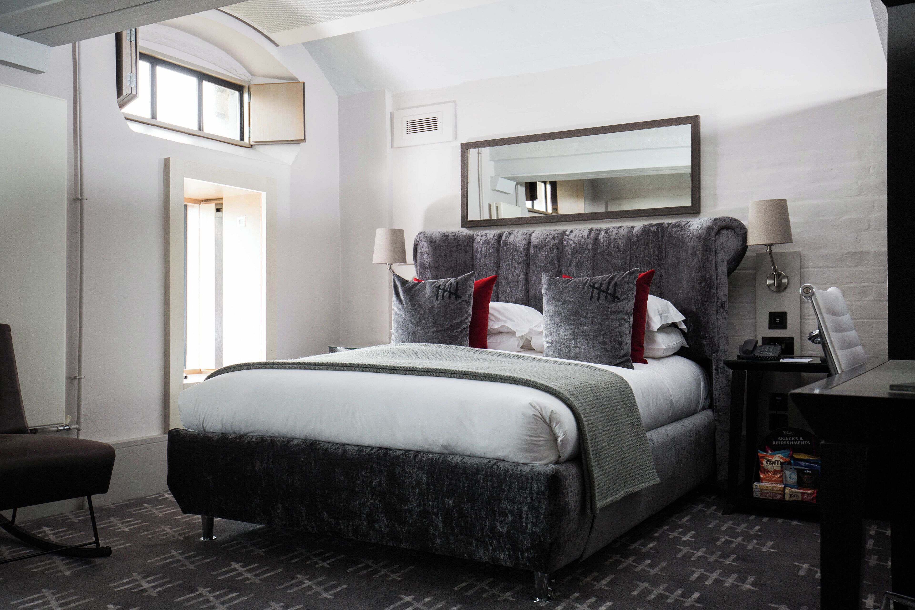 Un dormitorio moderno con una cama grande, un escritorio y una silla.