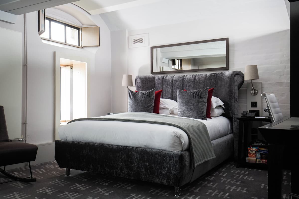 Un dormitorio moderno con una cama grande, un escritorio y una silla.