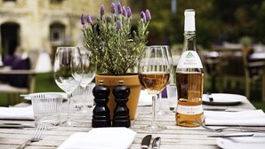 A table set for dining with a bottle of wine, glasses, and a potted plant with lavender. - Malmaison Oxford (Oxford)