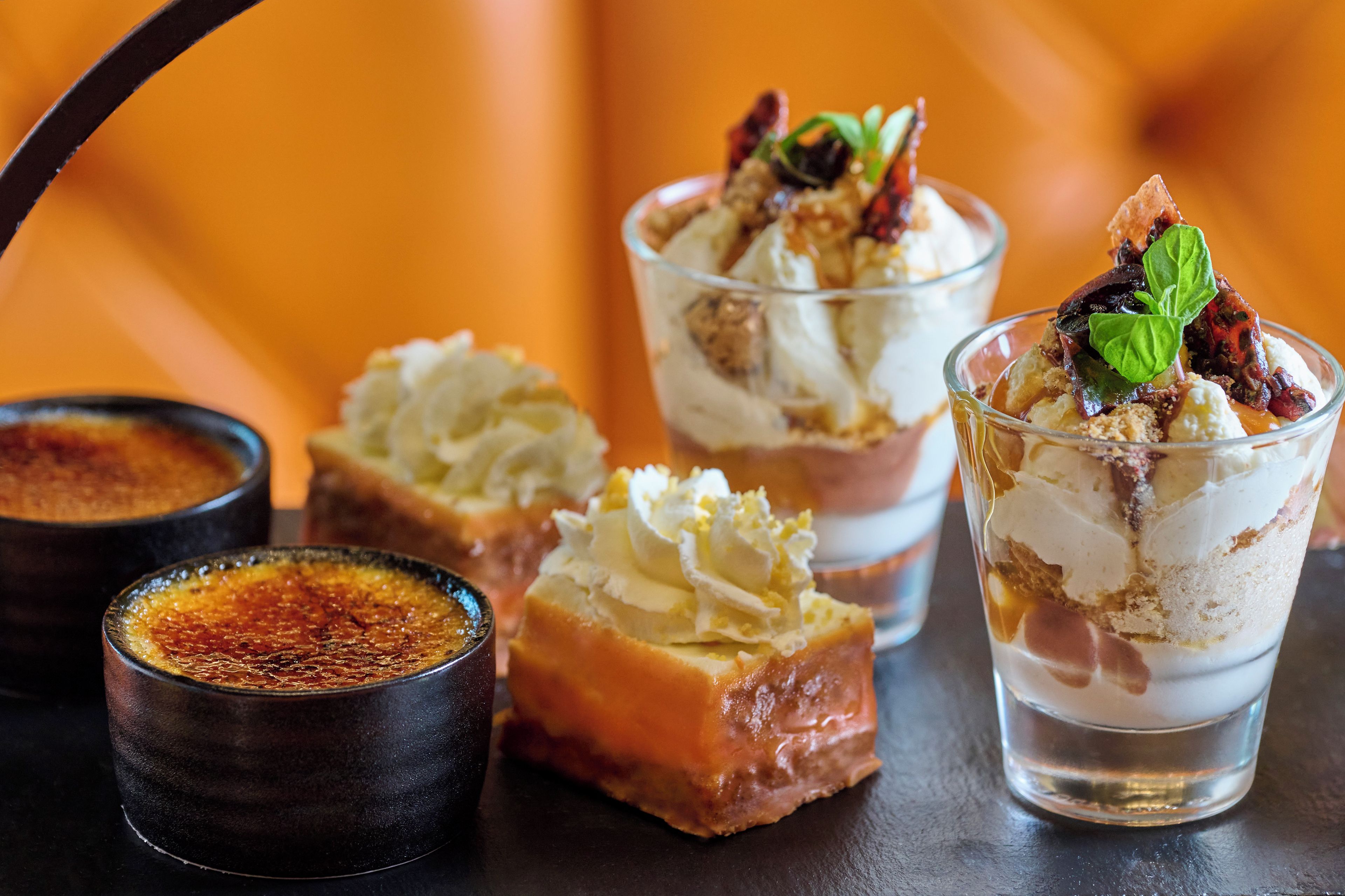 Uma mesa de sobremesas com diversos doces e uma pequena tigela de molho.