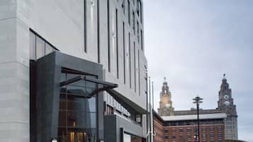 A modern building with a glass entrance and steps leading up to it.