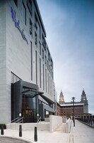 Un edificio moderno con un ingresso in vetro e gradini che vi conducono.