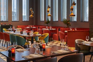 Un restaurante con varias mesas y sillas, algunas con velas.