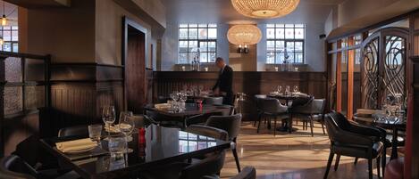 A spacious restaurant with high ceilings, large chandeliers, and a modern interior design.