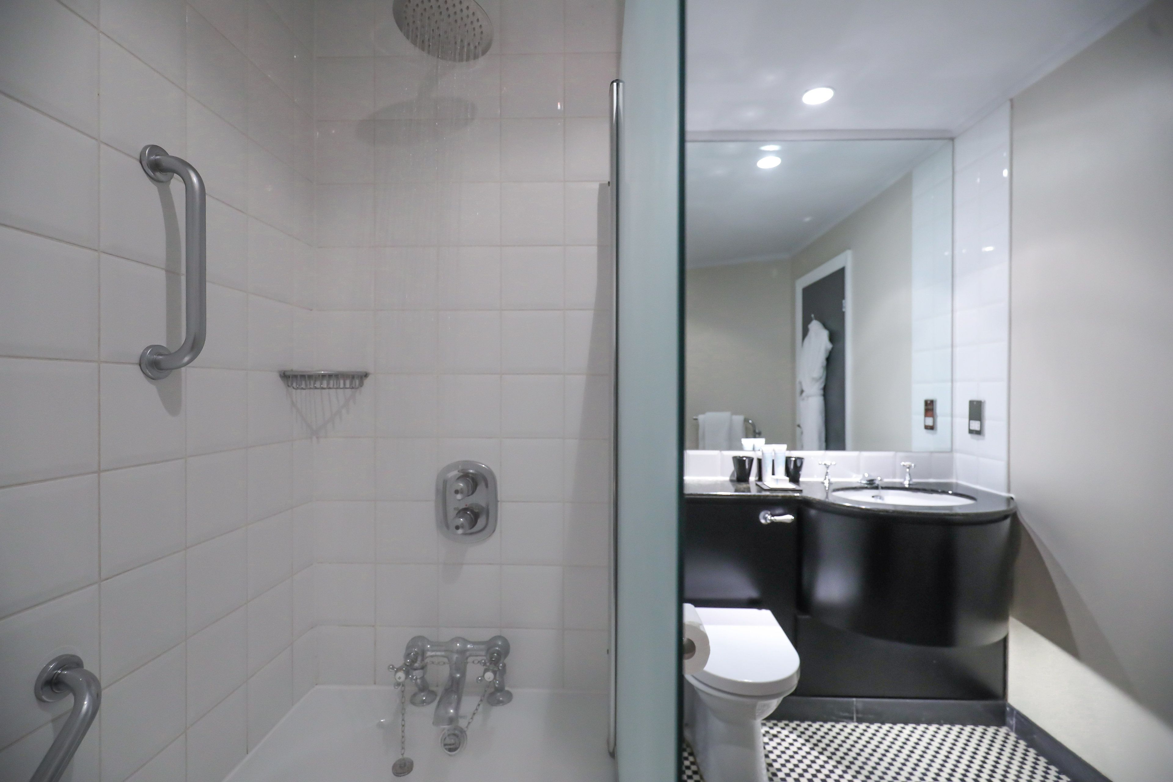 Een moderne badkamer met een douchecabine van glas, een toilet en een wastafel.