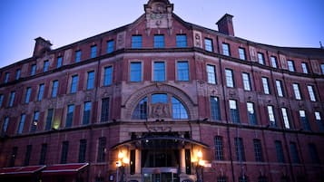 Un edificio grande e histórico con una entrada destacada y ventanas arqueadas.