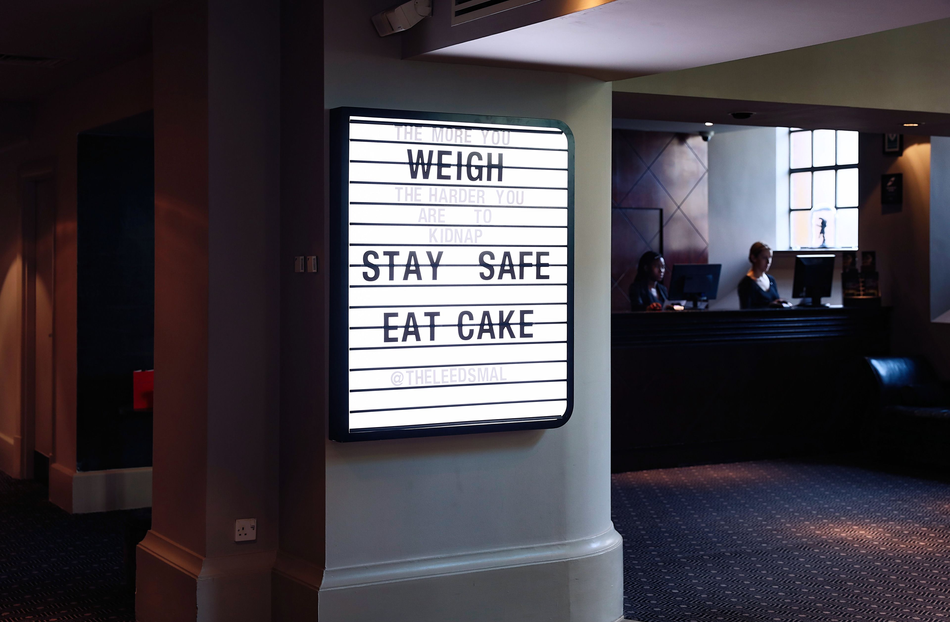 Une pancarte affichant un message humoristique dans le hall d’un hôtel.
