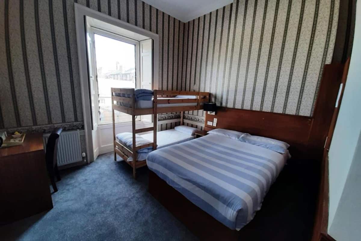 Une chambre avec un lit superposé, un bureau et un radiateur.