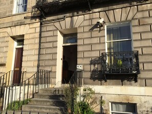 Un immeuble sur lequel on peut lire l’inscription : « HÔTEL ADELPHI, PAS DE CHAMBRES DISPONIBLES ».