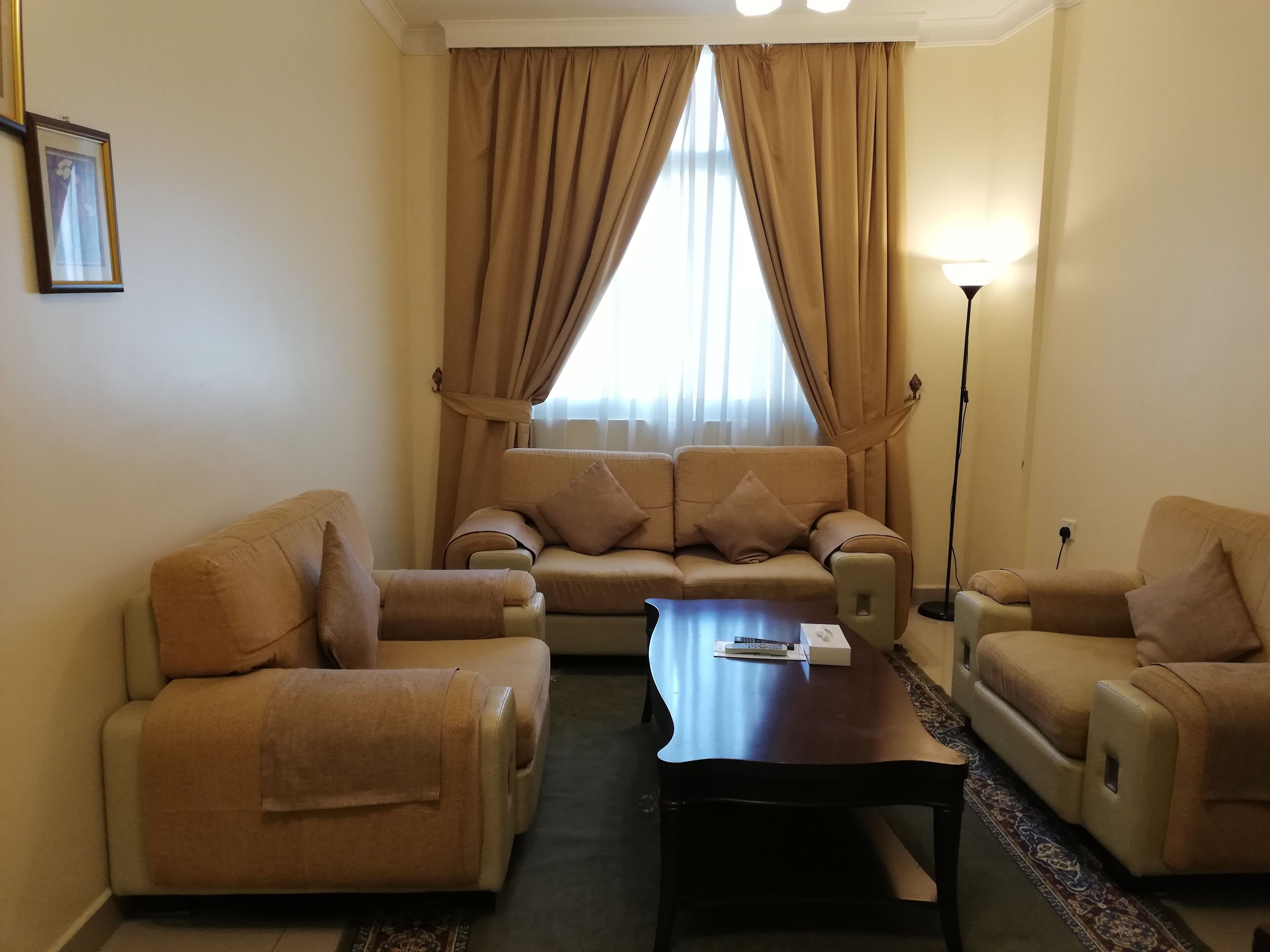 A living room with a sofa set, two armchairs, a coffee table, and a floor lamp.