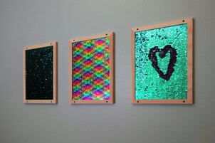 Tres obras de arte enmarcadas sobre una pared.
