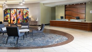A lobby with a reception desk, seating area, and colorful abstract artwork on the wall. - Residence Inn Youngstown Warren/Niles (Niles)