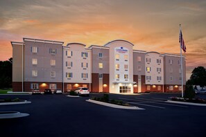 Ett hotell med modern design, flera våningar och en parkeringsplats.