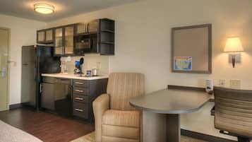 Une chambre d’hôtel compacte comprenant un coin cuisine, un espace repas et un coin salon.