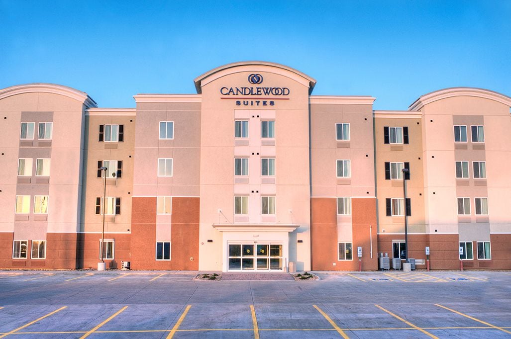 Un hotel de varios pisos con una entrada central, señalizada con un letrero que dice "CANDLEWOOD SUITES".