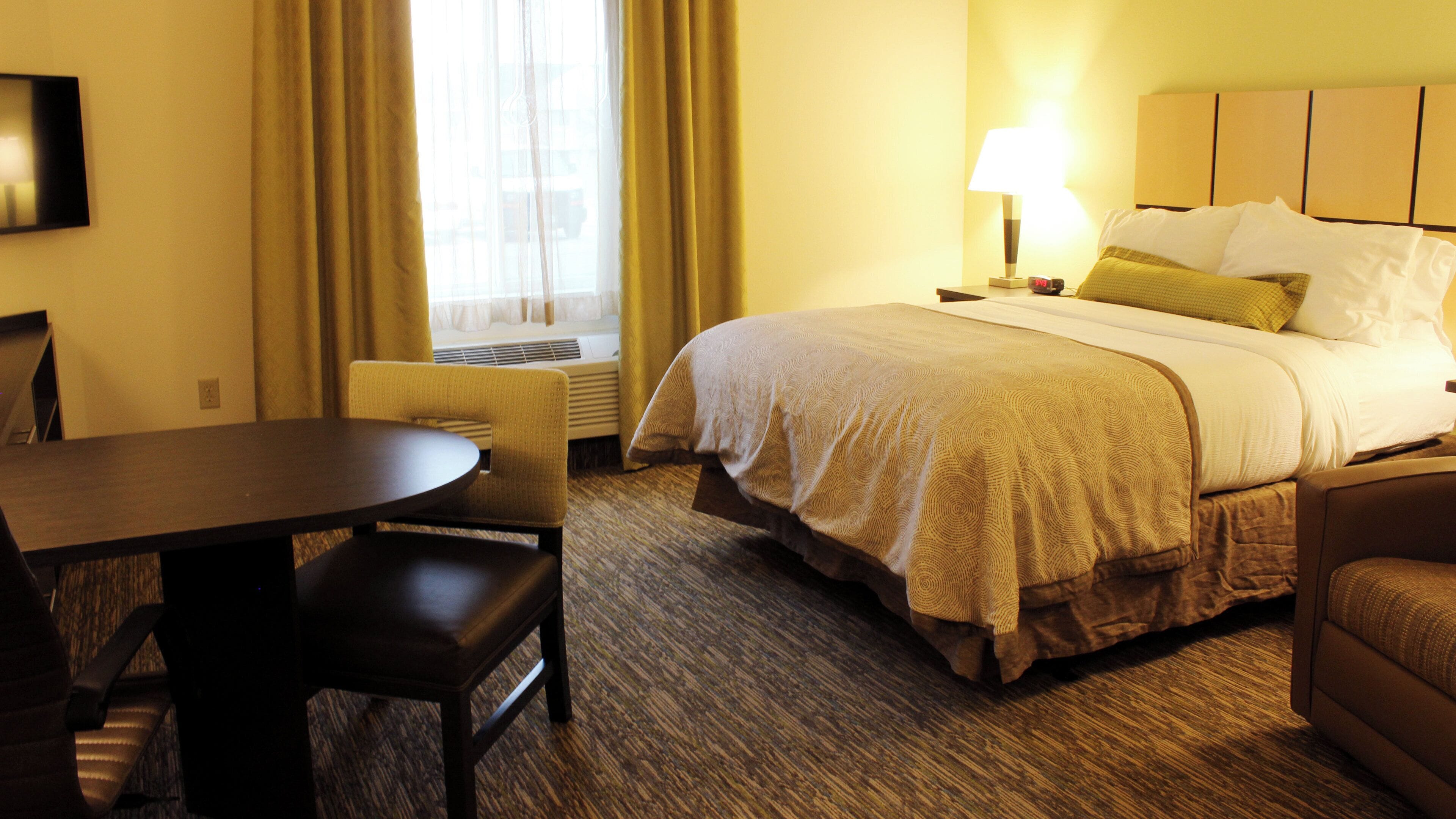 Ein Hotelzimmer mit Bett, Schreibtisch, Stuhl und Lampe.