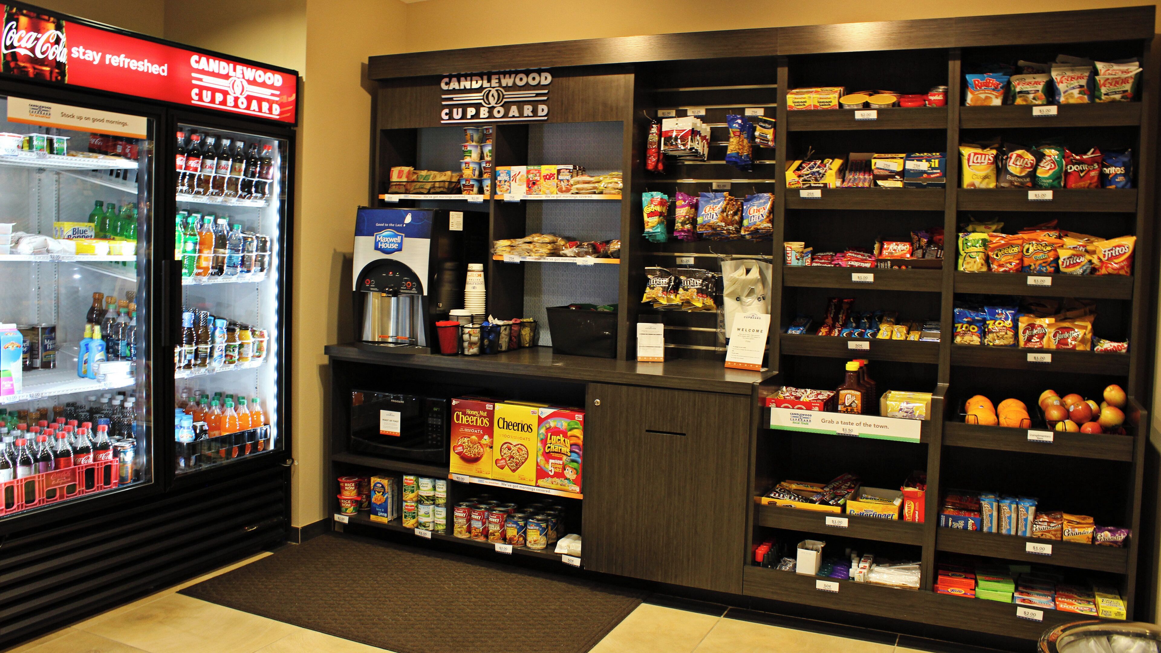 A snack and beverage area with shelves stocked with snacks, chips, and a beverage cooler.