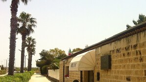 Un sentiero stretto circondato da palme e un edificio con la scritta "HOTEL CHAR".
