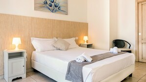Un letto ben rifatto con lenzuola bianche, due lampade sui comodini, una testiera in legno, un quadro sopra il letto e una sedia nell'angolo.