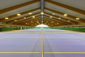 An indoor sports facility with a high ceiling, multiple sports courts, and green curtains along the walls. - Vienna Sporthotel (Vienna)