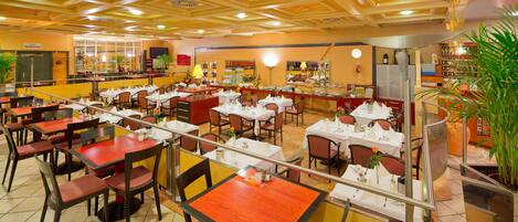 A spacious restaurant with multiple dining areas, including a bar and a buffet.