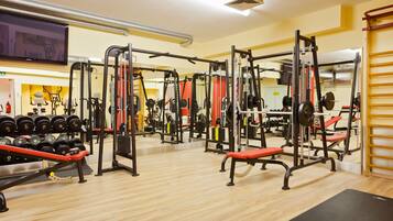 A gym with various exercise equipment, including weight machines and dumbbells.