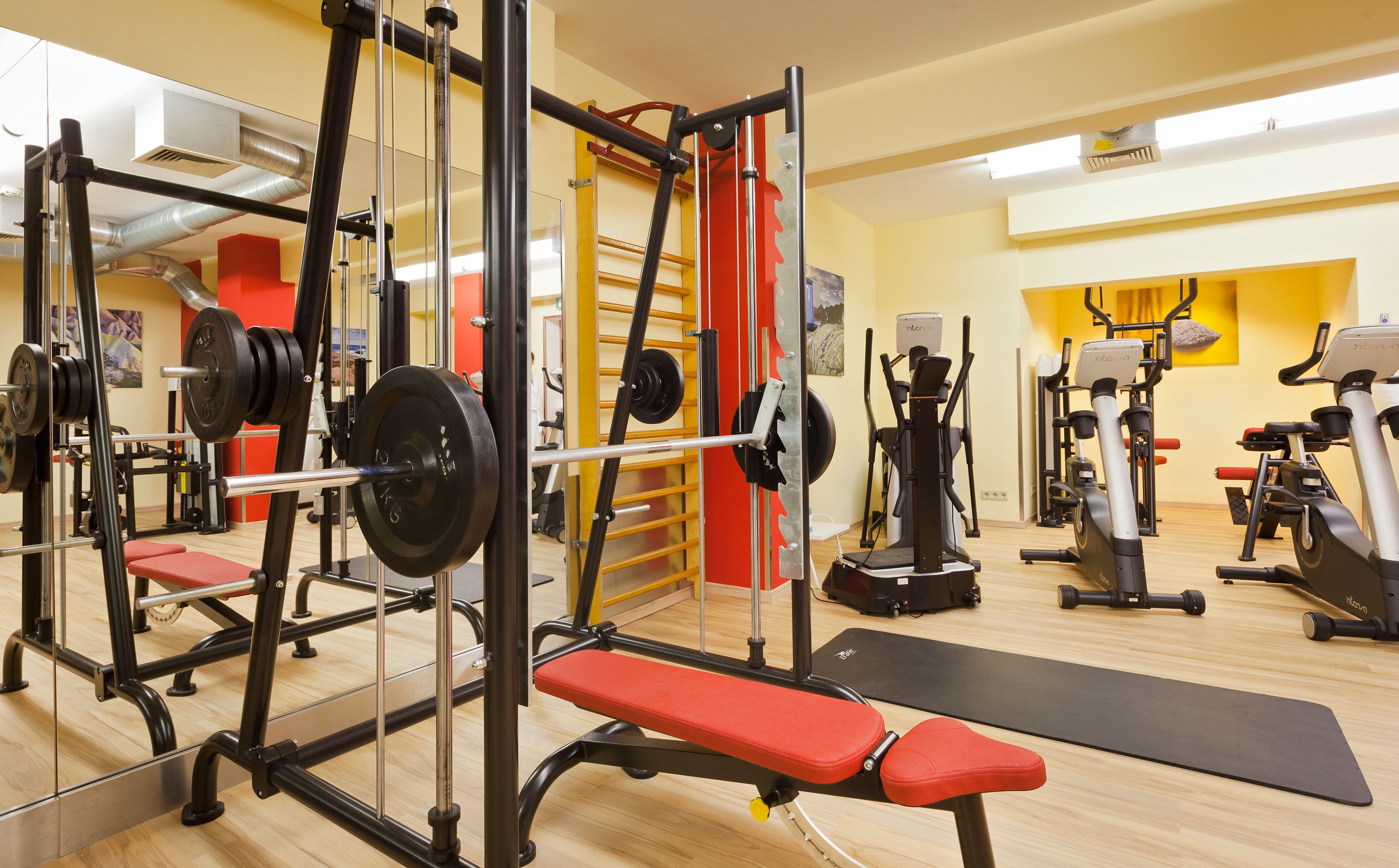 Une salle de sport équipée de matériel de musculation, de tapis de course et d’appareils d’exercice.