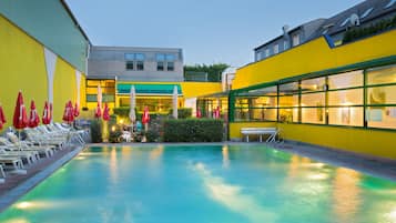 Relax by the pool surrounded by lounge chairs and umbrellas.