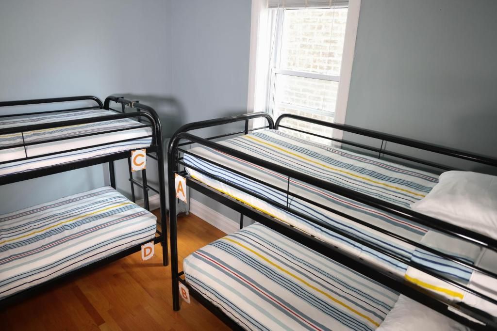A dormitory room with bunk beds labeled A, B, C, and D.