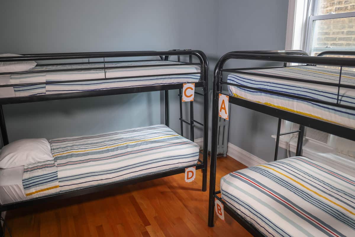 Des lits superposés avec du linge de lit à rayures, chacun étant identifié par les lettres A, B, C et D.