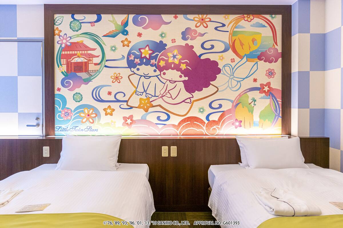 A hotel room with two beds, a colorful mural on the wall, and a window with a view.