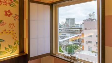 Una habitación con un amplio ventanal que da a una vista urbana con edificios y un puente.