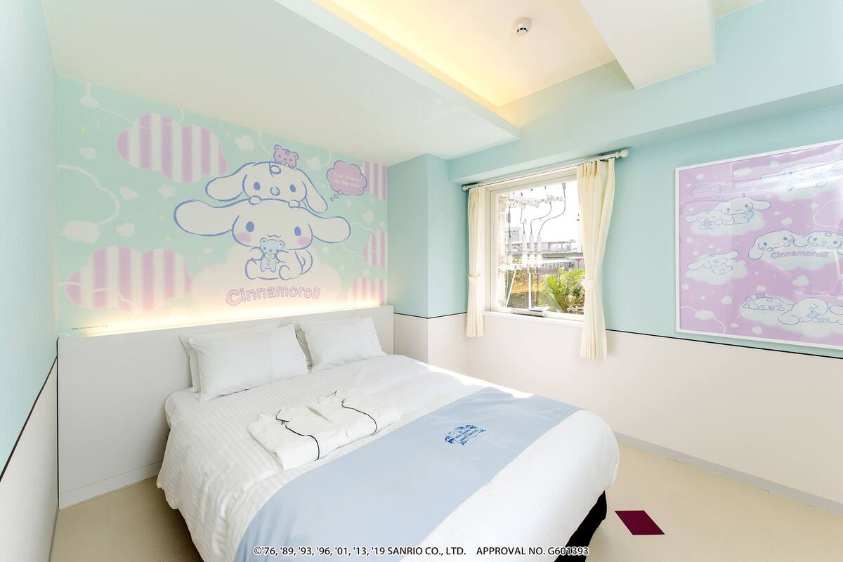 A bedroom with a bed, a window, and wall decorations.