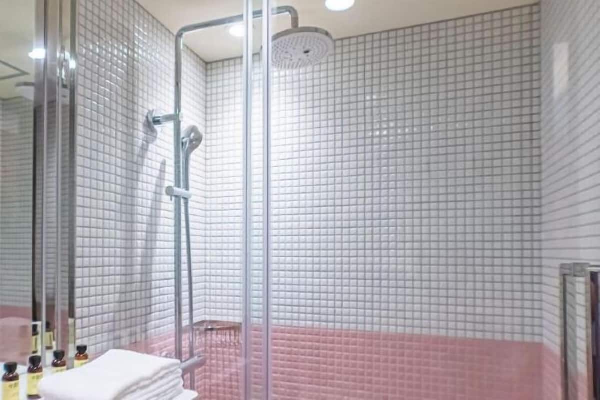 Badkamer | Een douche, designer toiletartikelen, een haardroger, badjassen