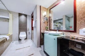 A modern bathroom with a toilet, sink, and mirror. - Huaan International Hotel (Shenzhen)