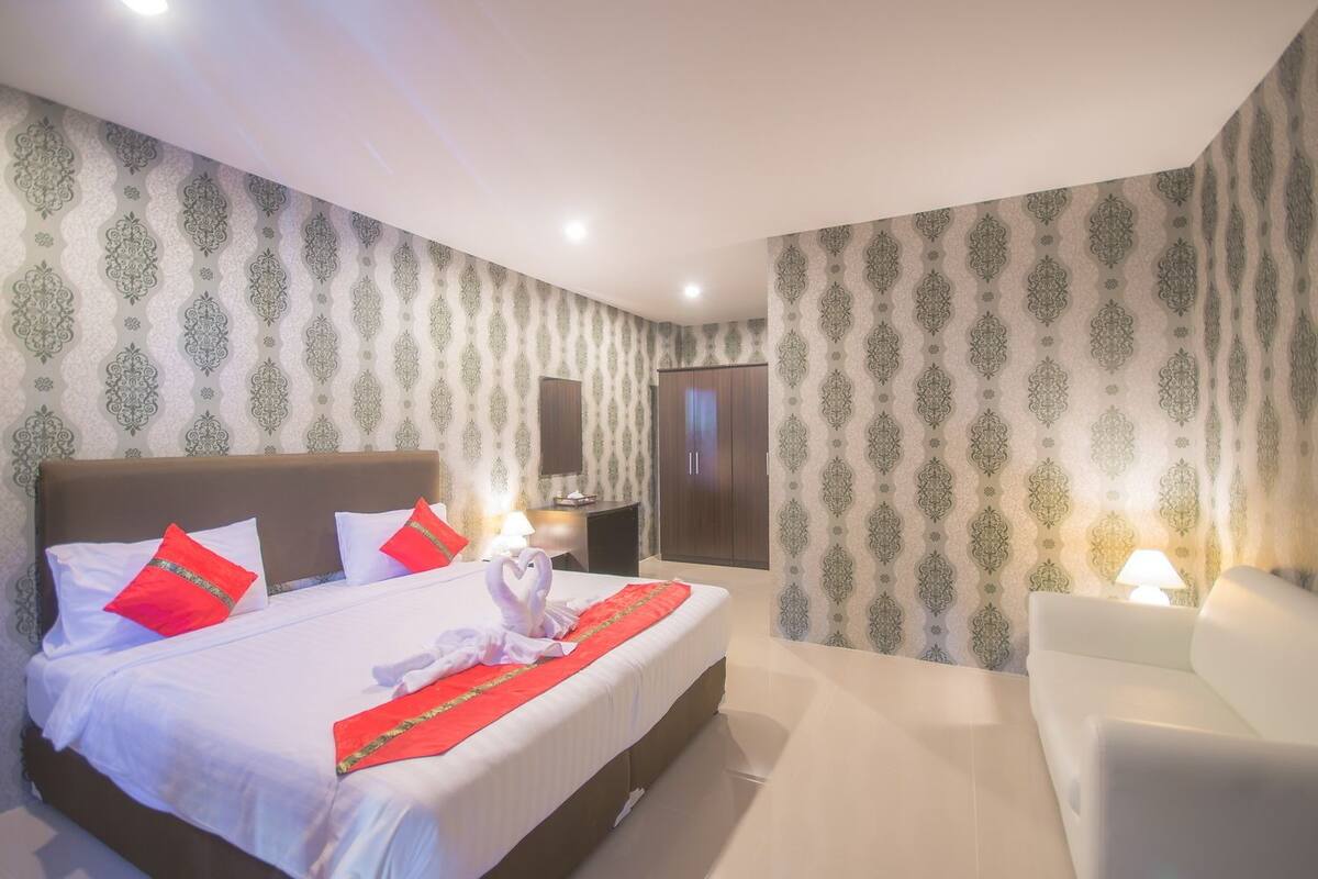 Een hotelkamer met een groot bed, een bureau en een stoel.