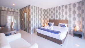 A modern hotel room with a large bed, a desk, and a chair. - Grande Elegance Serviced Apartment (Patong)