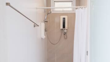 A modern bathroom with a shower, a glass door, and a towel rack.