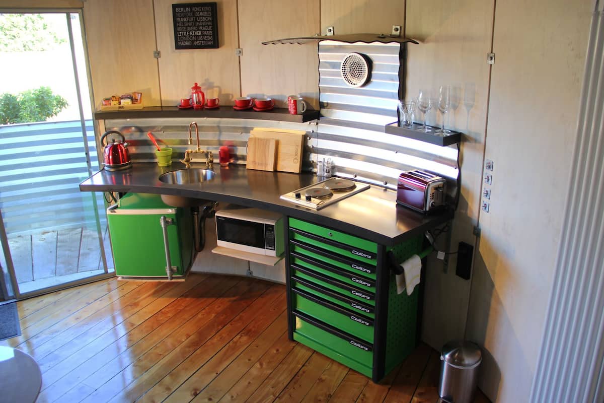 A compact kitchen with a sink, a toaster, and a coffee maker.